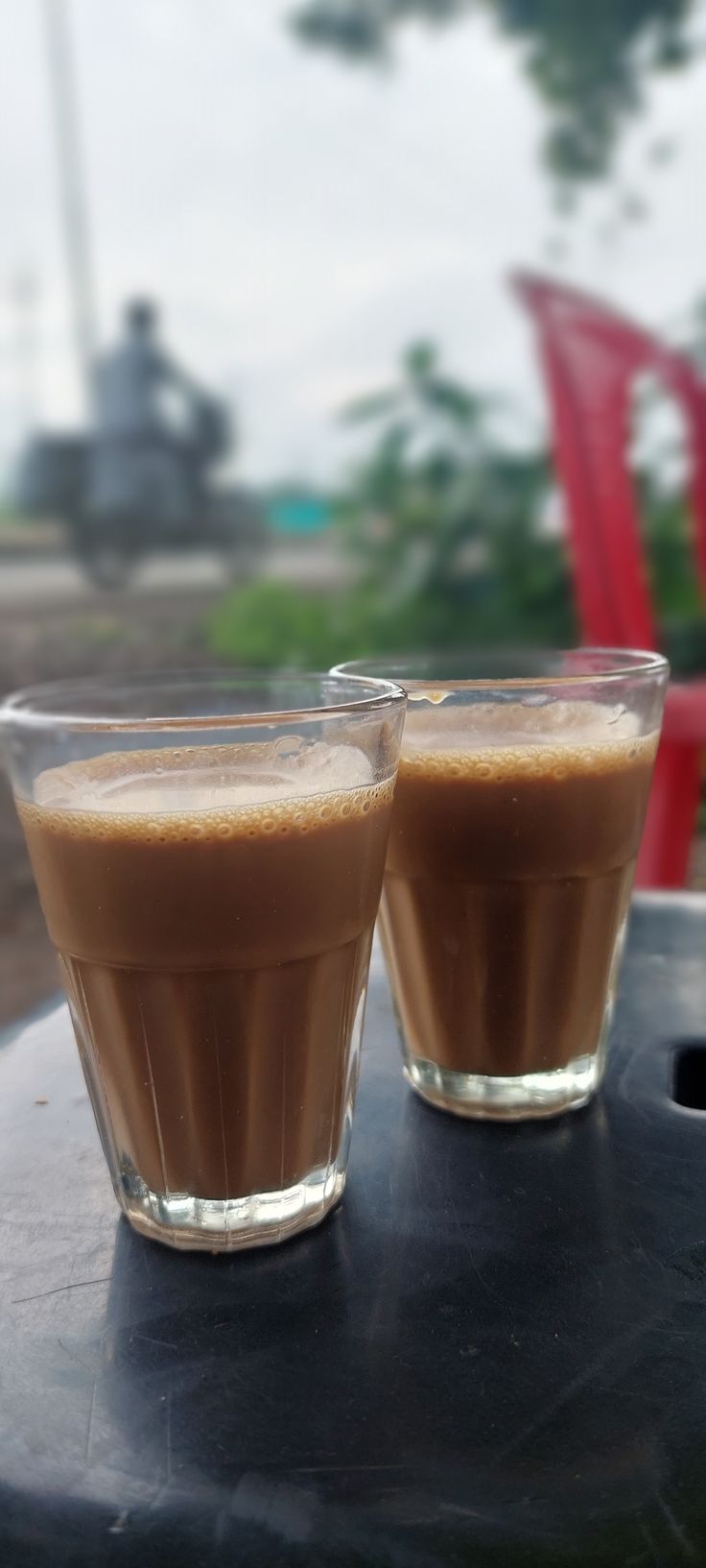 two glasses filled with liquid sitting on top of a table