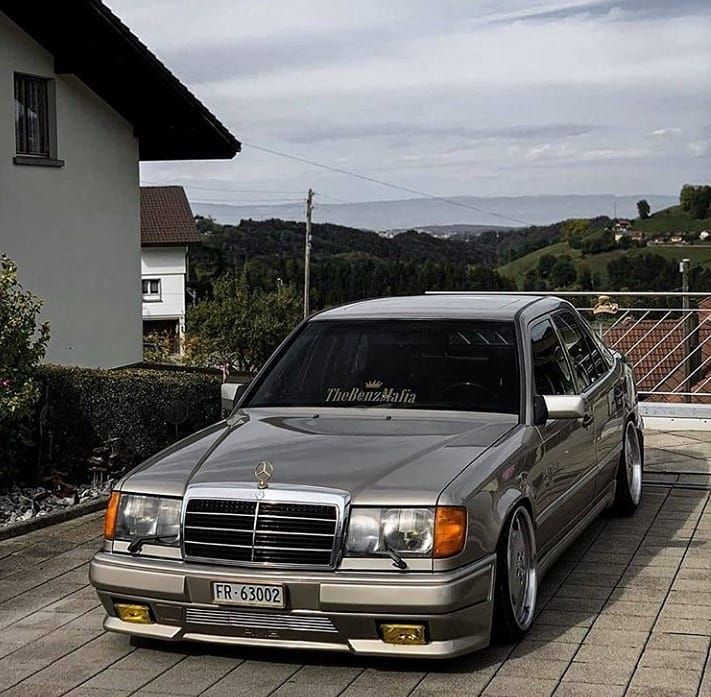 a silver mercedes parked in front of a house