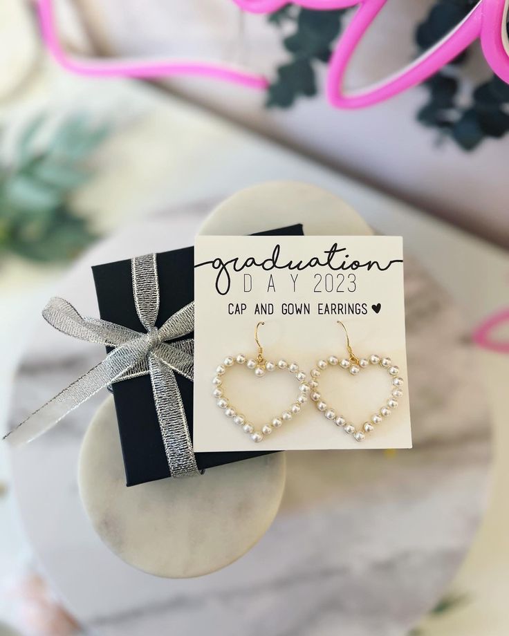 Our Pearl Heart Statement Earrings are the perfect additional to your cap and gown for graduation day! These earrings are the perfect gift to commemorate your day! At Love Leigh Gift Co. we take pride in using the finest materials and craftsmanship to make your one of a kind, breathtaking personalized jewelry With your purchase you receive: 1 Personalized card with message of your choice 1 Pair of Pearl heart dangle statement earrings! 1 Box & Ribbon (31/2 x 31/2 x 1 inch box) THE LOVE LEIGH GIF Elegant Personalized Jewelry For Graduation Gift, Elegant Adjustable Heart Earrings For Gift, Mother's Day Wedding Heart Dangle Earrings, Adjustable Heart-shaped Wedding Earrings, Adjustable Earrings For Valentine's Day Gift, Elegant Personalized Heart Earrings For Gift, Heart Drop Earrings For Gifts, Heart Shaped Drop Earrings For Gifts, Personalized Heart Earrings For Valentine's Day Anniversary