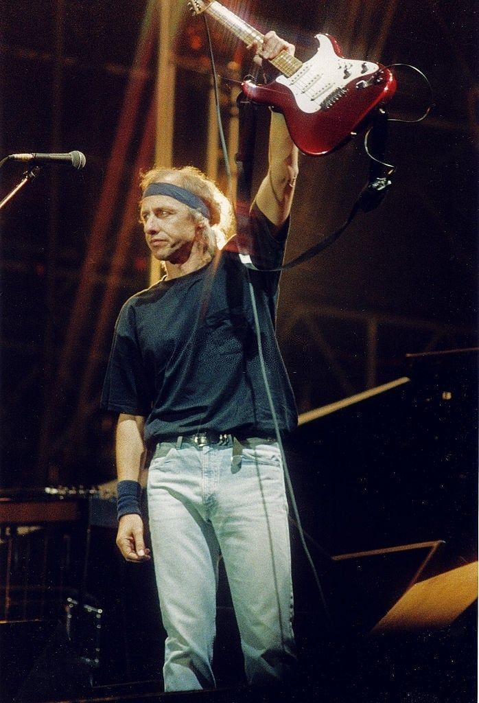 an image of a man that is holding up a guitar in front of his head