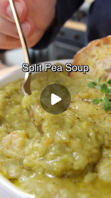 a bowl filled with green soup next to a piece of bread