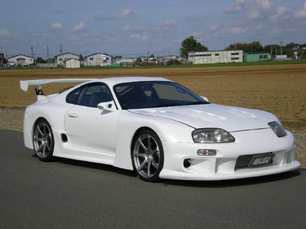 a white sports car is parked on the road