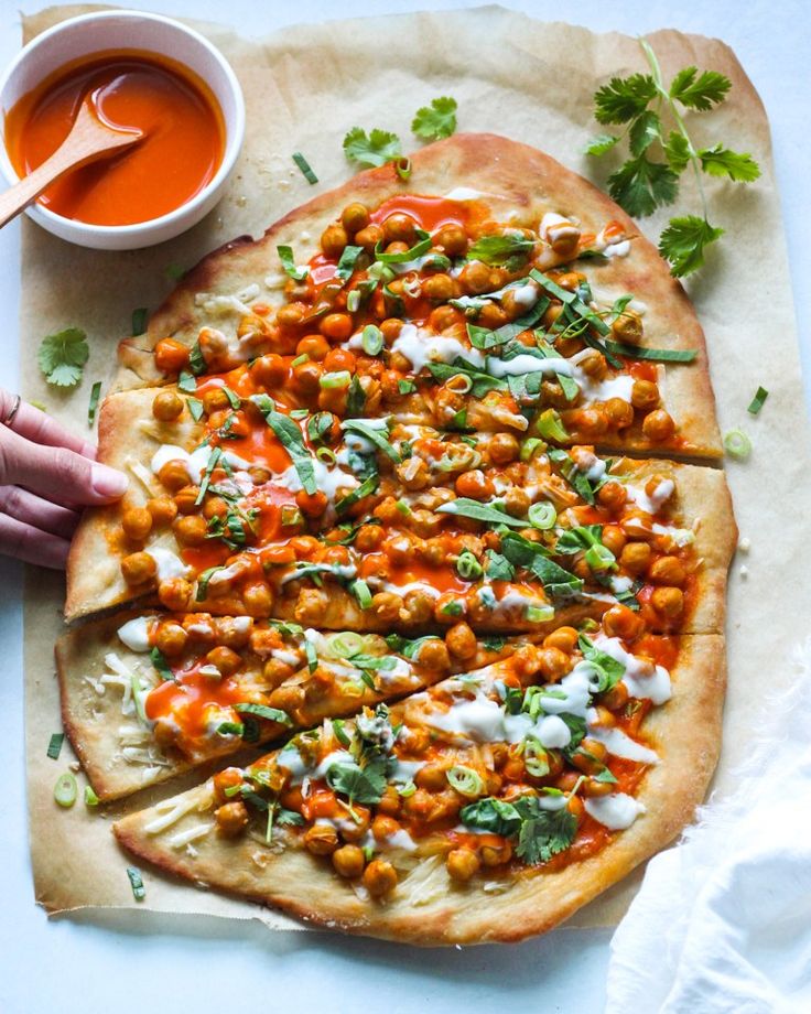 a flatbread pizza topped with chickpeas and garbanzo sauce