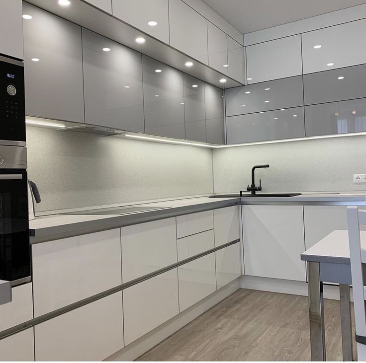 a modern kitchen with white cabinets and stainless steel appliances