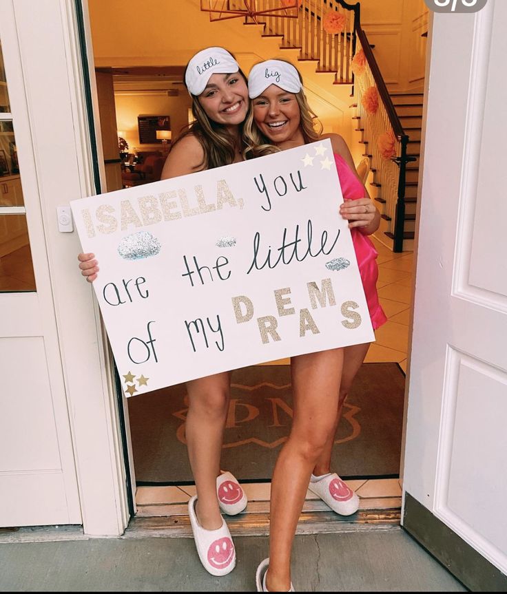 two girls holding up a sign that says, i love you are the little of my dreams