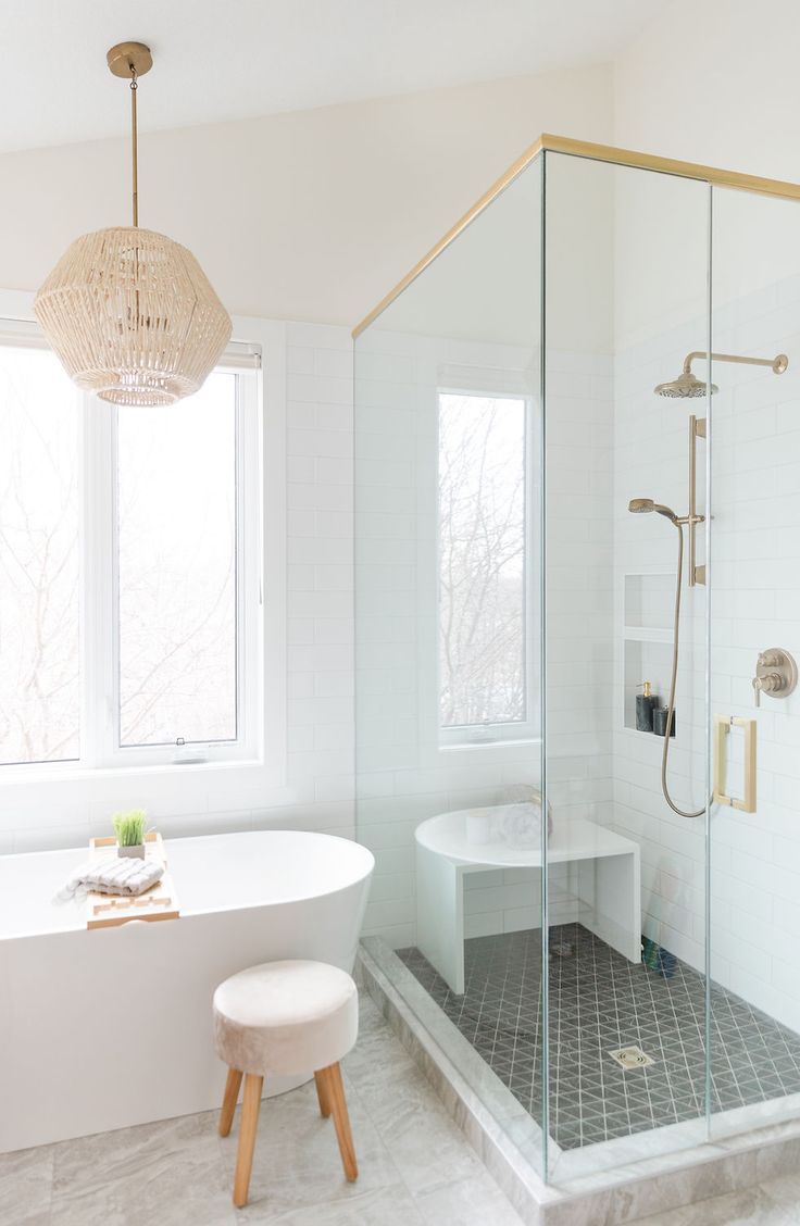 a bathroom with a tub, shower and stool in the corner next to the window