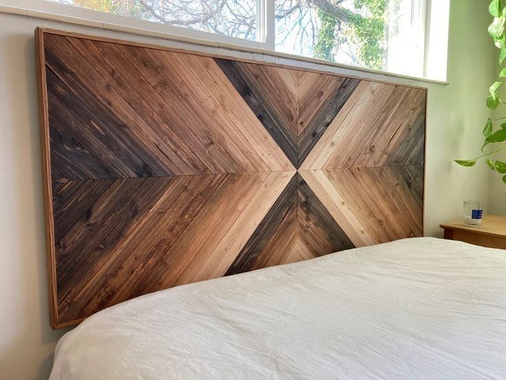 a bed with a wooden headboard made out of wood planks and white sheets