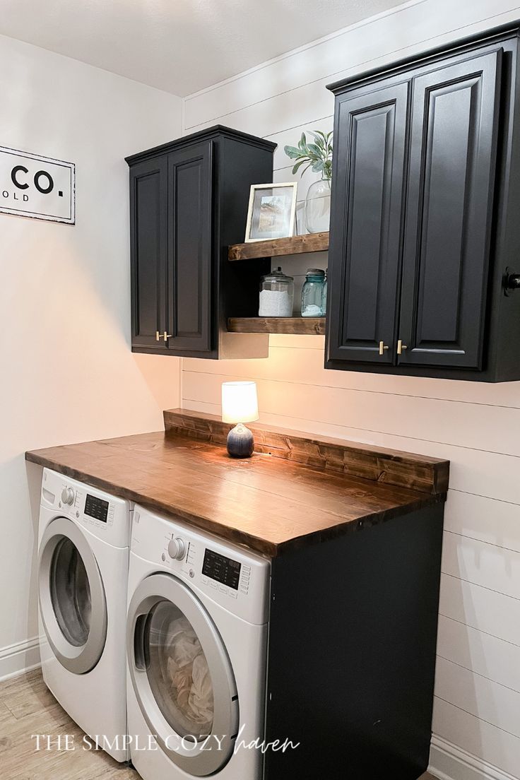 a washer and dryer in a small room with wood counter tops on the floor