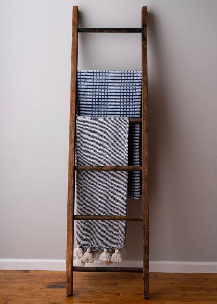 an old wooden ladder with towels hanging on it