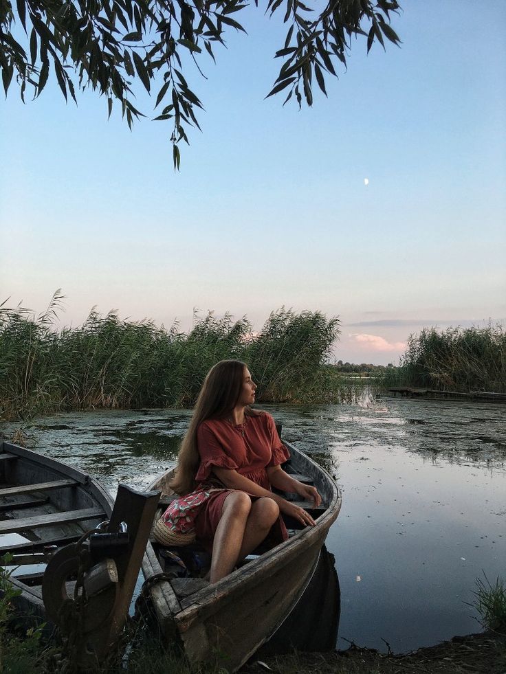 a woman is sitting in a boat on the water