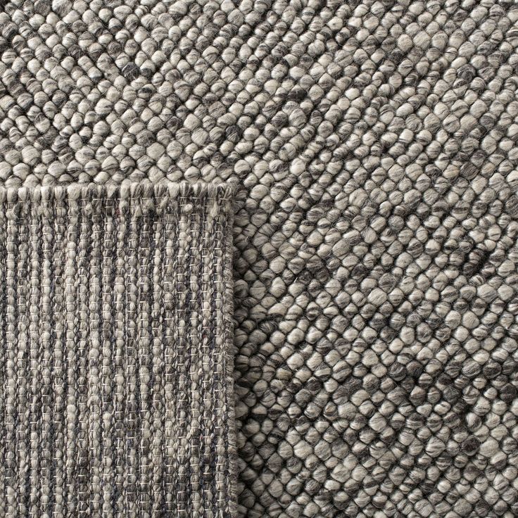 the texture of an upholstered rug is shown in grey and white tones, with a