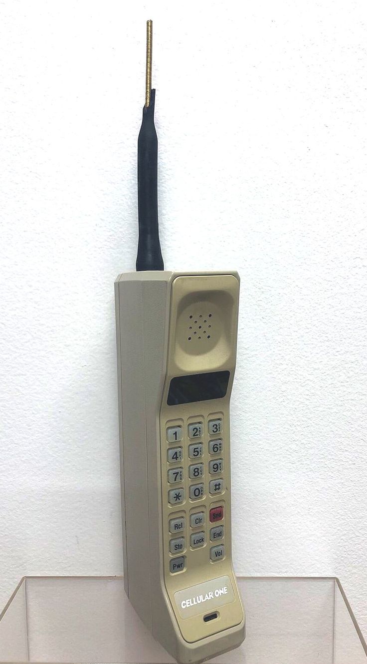 an old style phone sitting on top of a clear shelf with a black cord attached to it