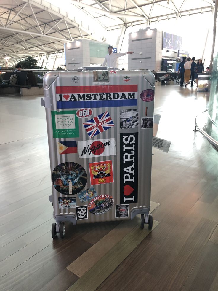 a suitcase with stickers on it sitting in an airport