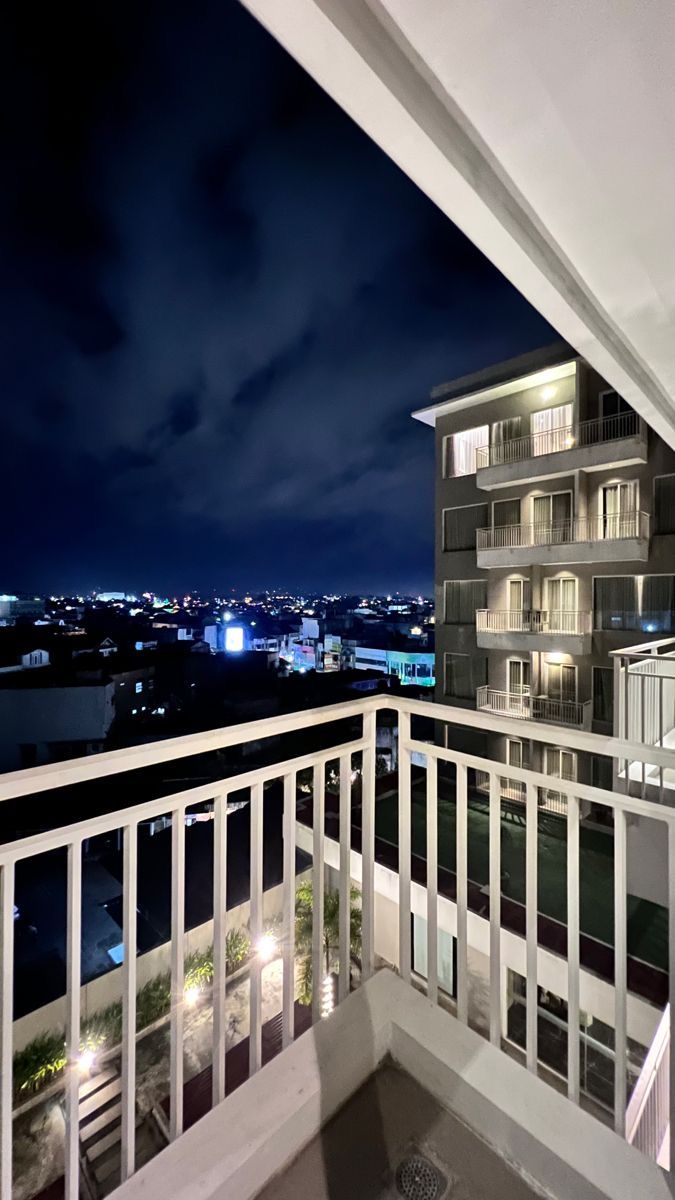 an apartment balcony overlooking the city at night