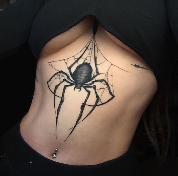 a woman with a spider tattoo on her stomach and the bottom part of her body