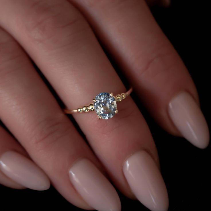 a woman's hand holding a diamond ring