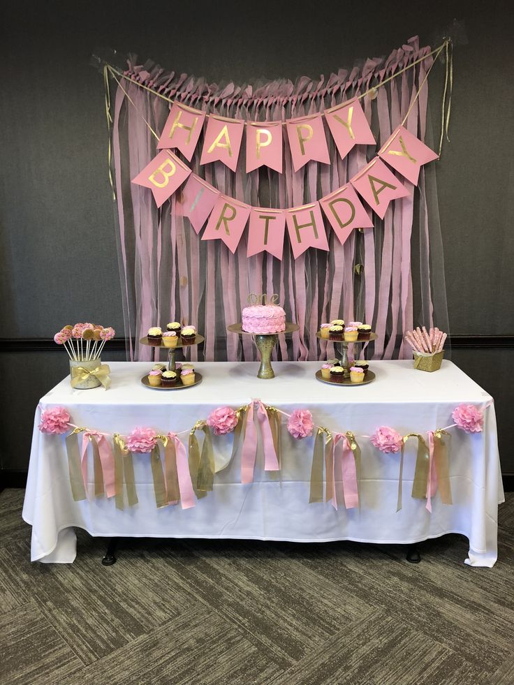 a pink and gold happy birthday party with cake, cupcakes and streamers