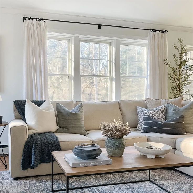 a living room filled with lots of furniture and pillows on top of a coffee table