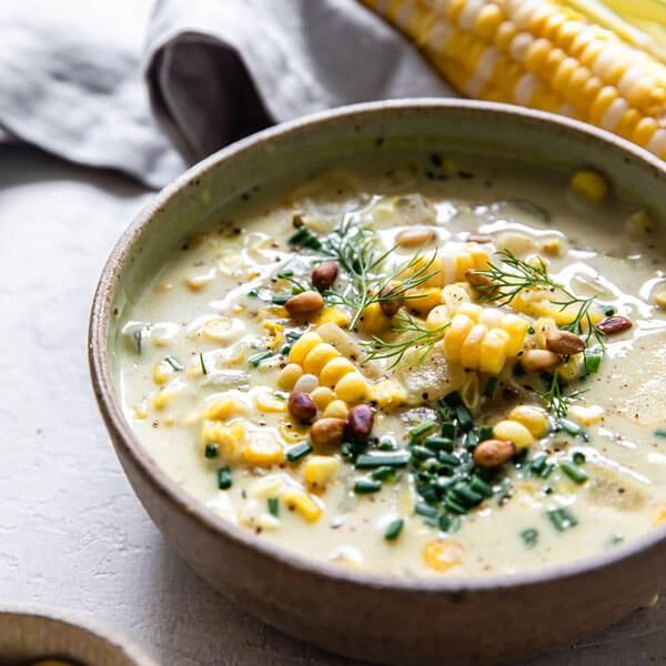 a bowl of soup with corn on the cob