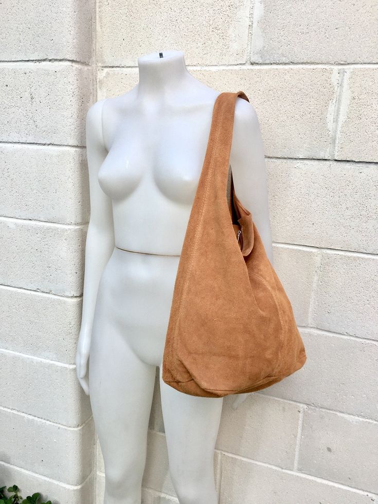 a white mannequin holding a brown purse