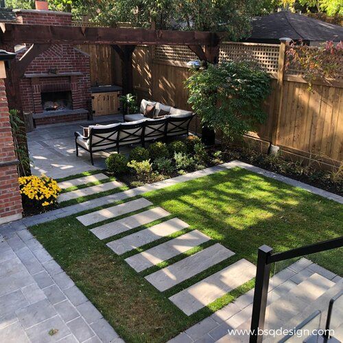 an outdoor patio with grass and stepping stones