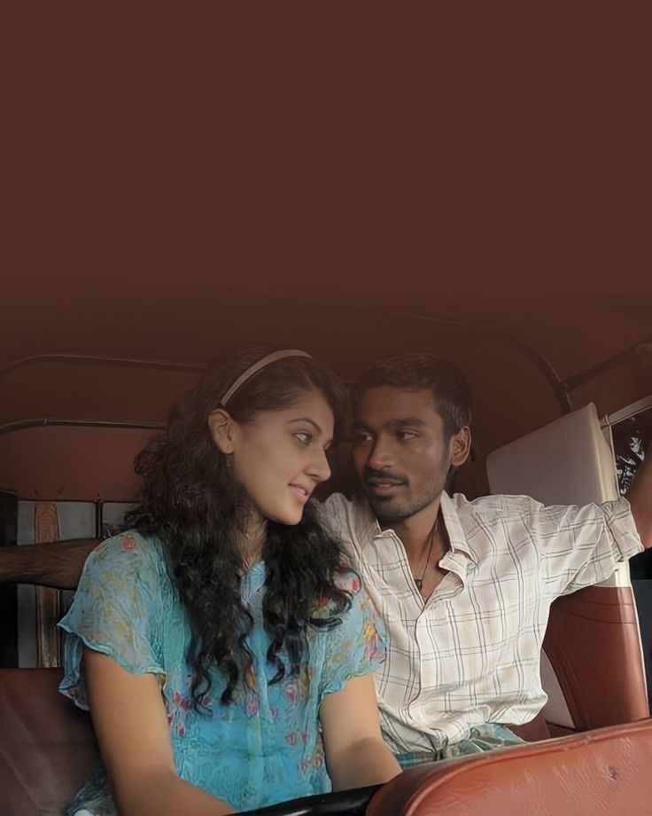 a man and woman are sitting in the back of a car looking at each other