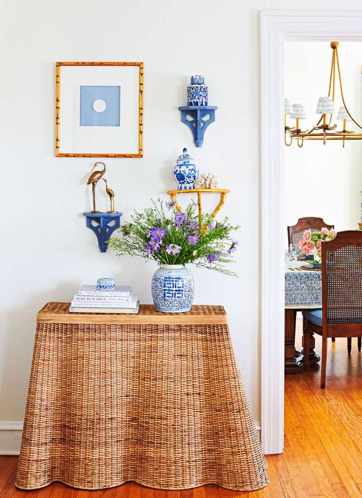 a dining room table with blue and white vases on top of it next to a wooden floor