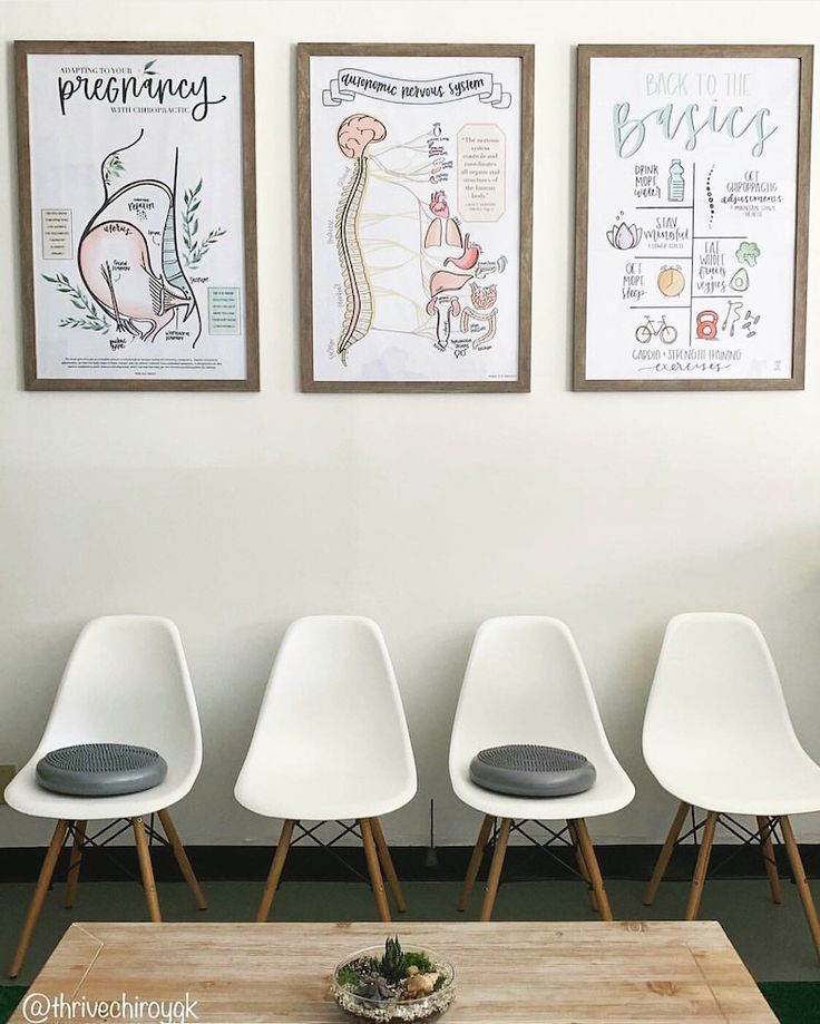 four white chairs are lined up against the wall in front of three pictures on the wall