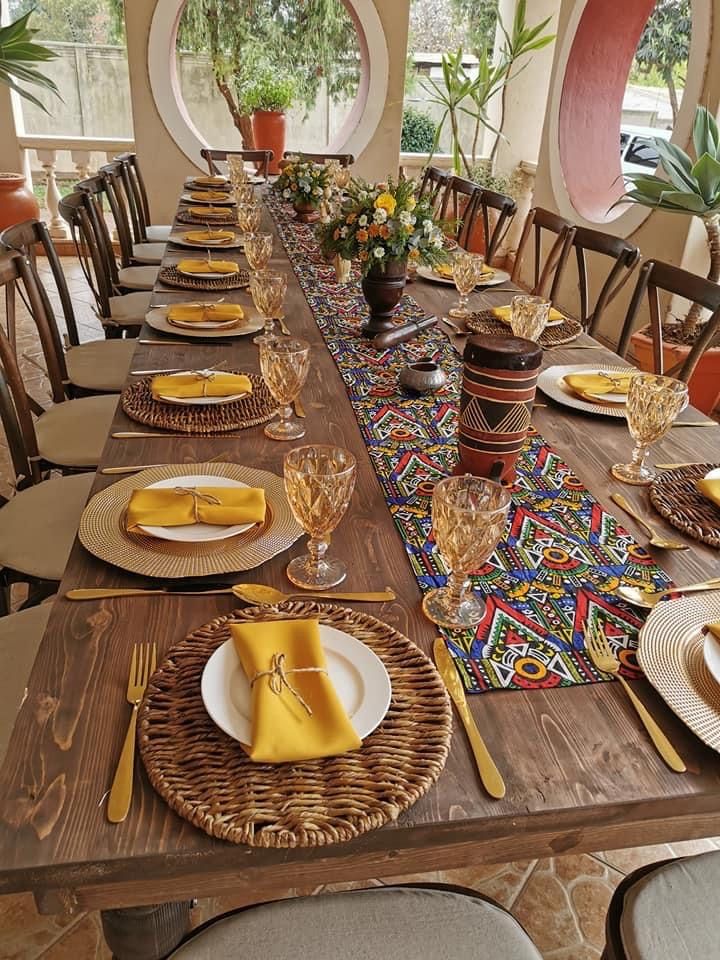 a long table with place settings and plates on it in front of large round windows