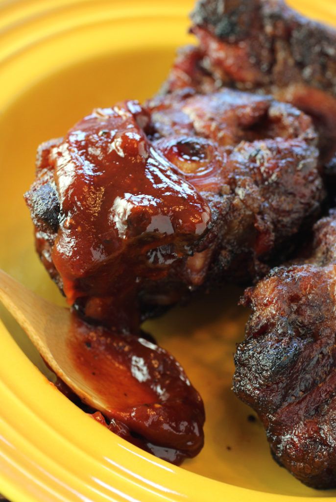 two pieces of meat on a yellow plate next to a fork and some ketchup