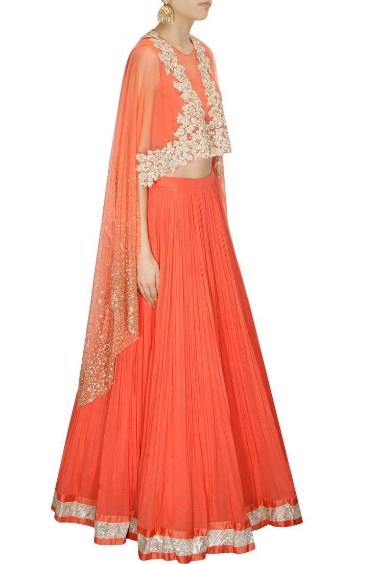 This Coral Lehenga Choli is features in cape top with floral embroidery and scattered sequins on sleeves. This coral lehenga choli comes along with matching chiffon pleated lehenga with silver border and coral shantoon sleeveless inner. This product is inspired from Ridhi Mehra Collection. Pleated Lehenga, Ridhi Mehra, Cape Top, Cape Tops, Lehenga Choli, Dress Patterns, Floral Embroidery, Lehenga, Victorian Dress