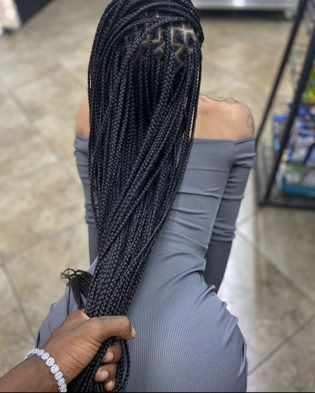 the back of a woman's head with long box braids