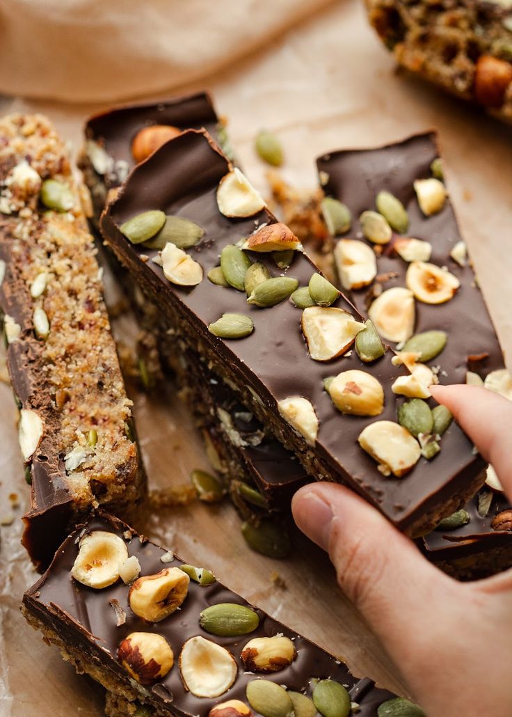 a person holding some kind of chocolate bar with nuts on it's wrapper