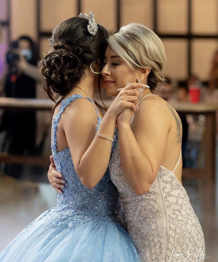 two women in blue dresses hugging each other