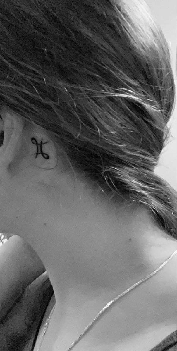 a woman with a cross tattoo on her left ear