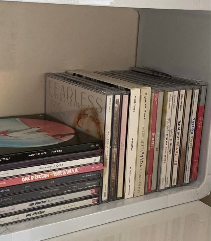 there are many cd's on the shelf next to each other