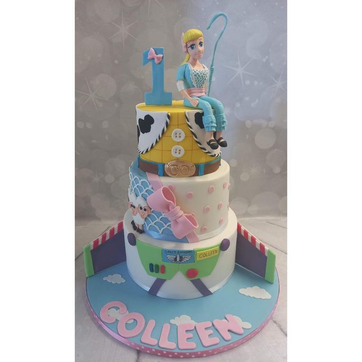 a three tiered cake with toy figures on it's top and bottom layer