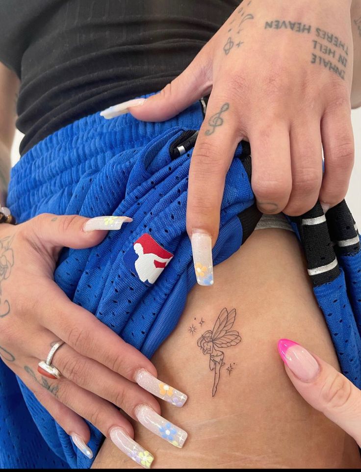 a woman with tattoos on her stomach holding onto a blue bag