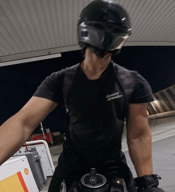 a man riding on the back of a motorcycle wearing a helmet and goggles