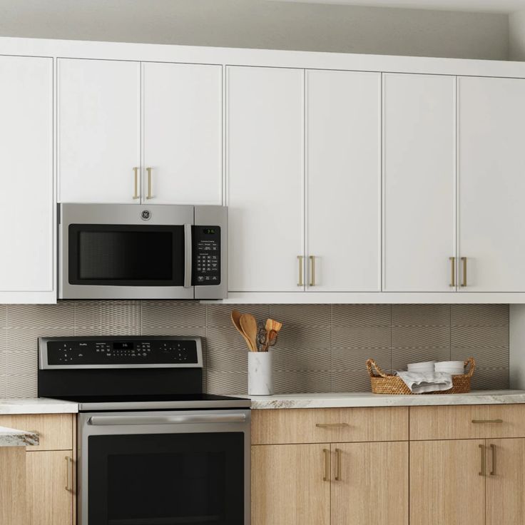 a kitchen with white cupboards and stainless steel microwave above the stove, along with wooden cabinets