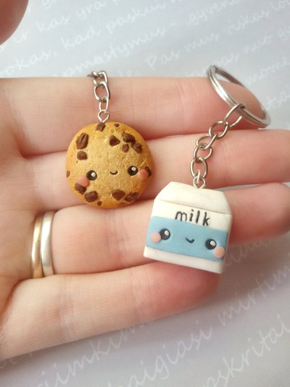 a hand holding a cookie and a keychain with a cute face on it