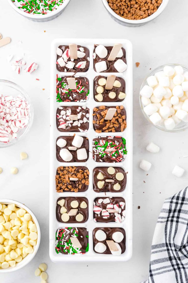 a tray filled with candy and marshmallows on top of a white table