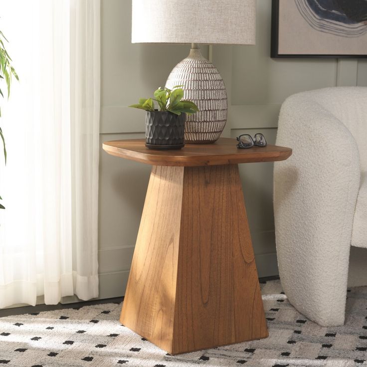 a wooden table with a plant on it next to a white chair