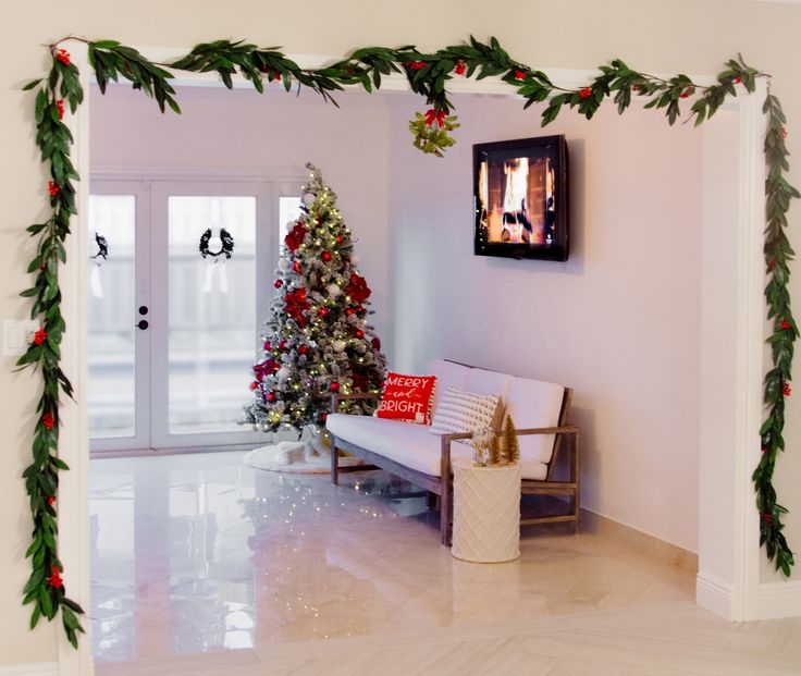 a living room decorated for the holidays with christmas decorations and garlands on the wall