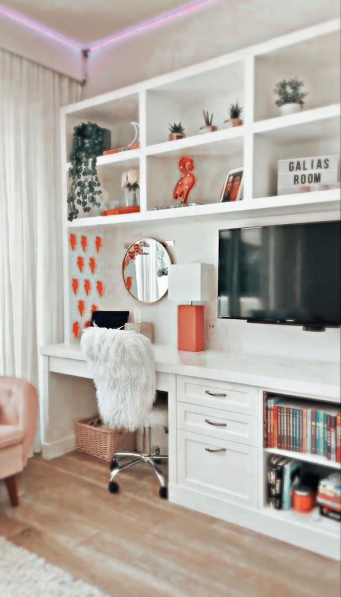 a living room with white furniture and orange accents