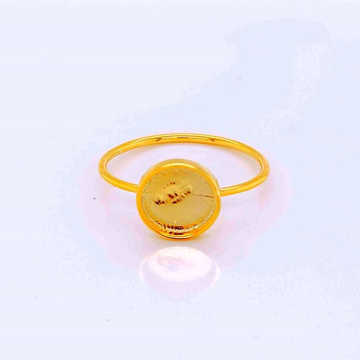 a gold ring with a coin on it