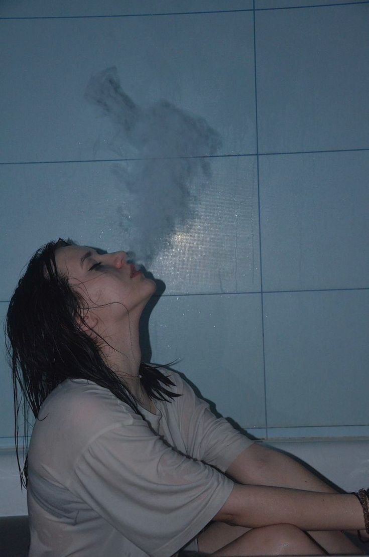 a woman is sitting in the bathtub with steam coming out of her mouth and head