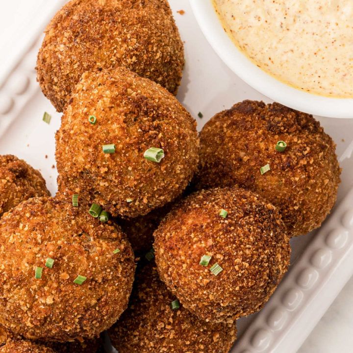 some food is sitting on a plate next to a bowl of dip and dipping sauce