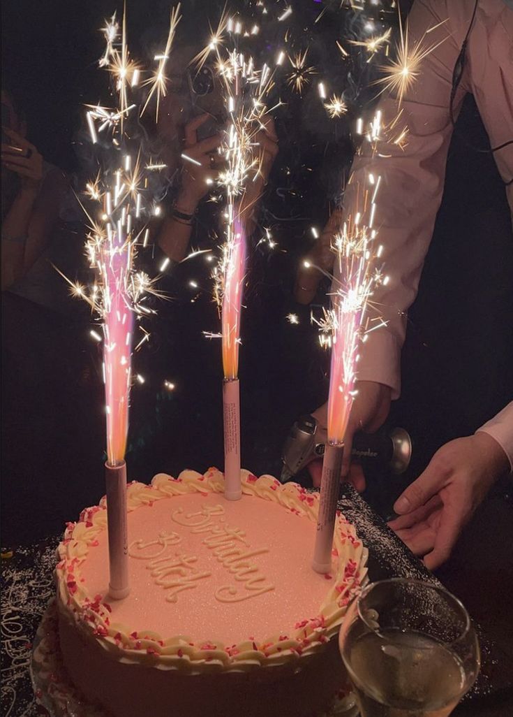 a birthday cake with sparklers on it and the words happy birthday written on top