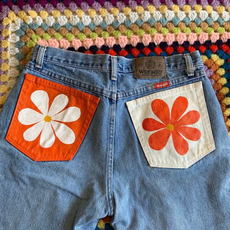 a pair of jean shorts with flower appliques on them